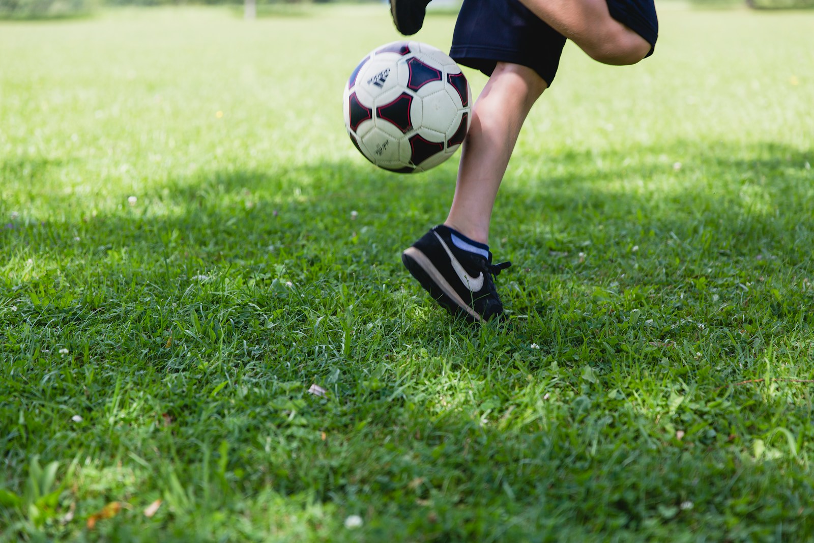 person running while kicking the ball