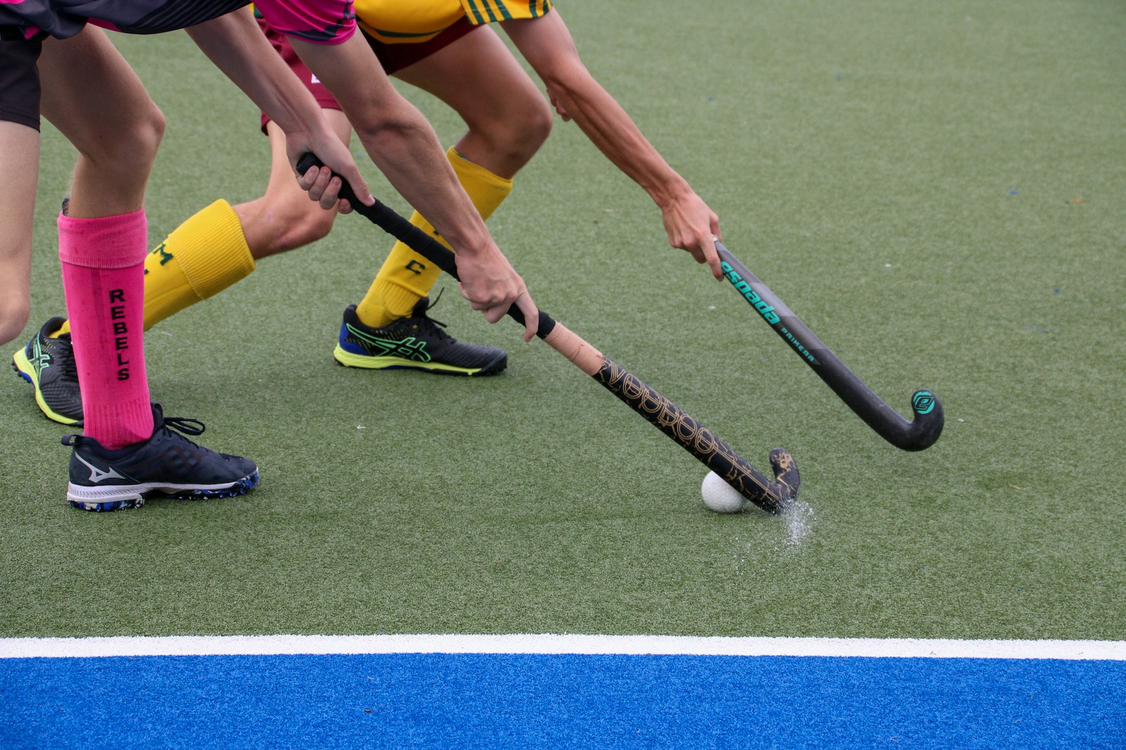 A group of people playing a game of field hockey